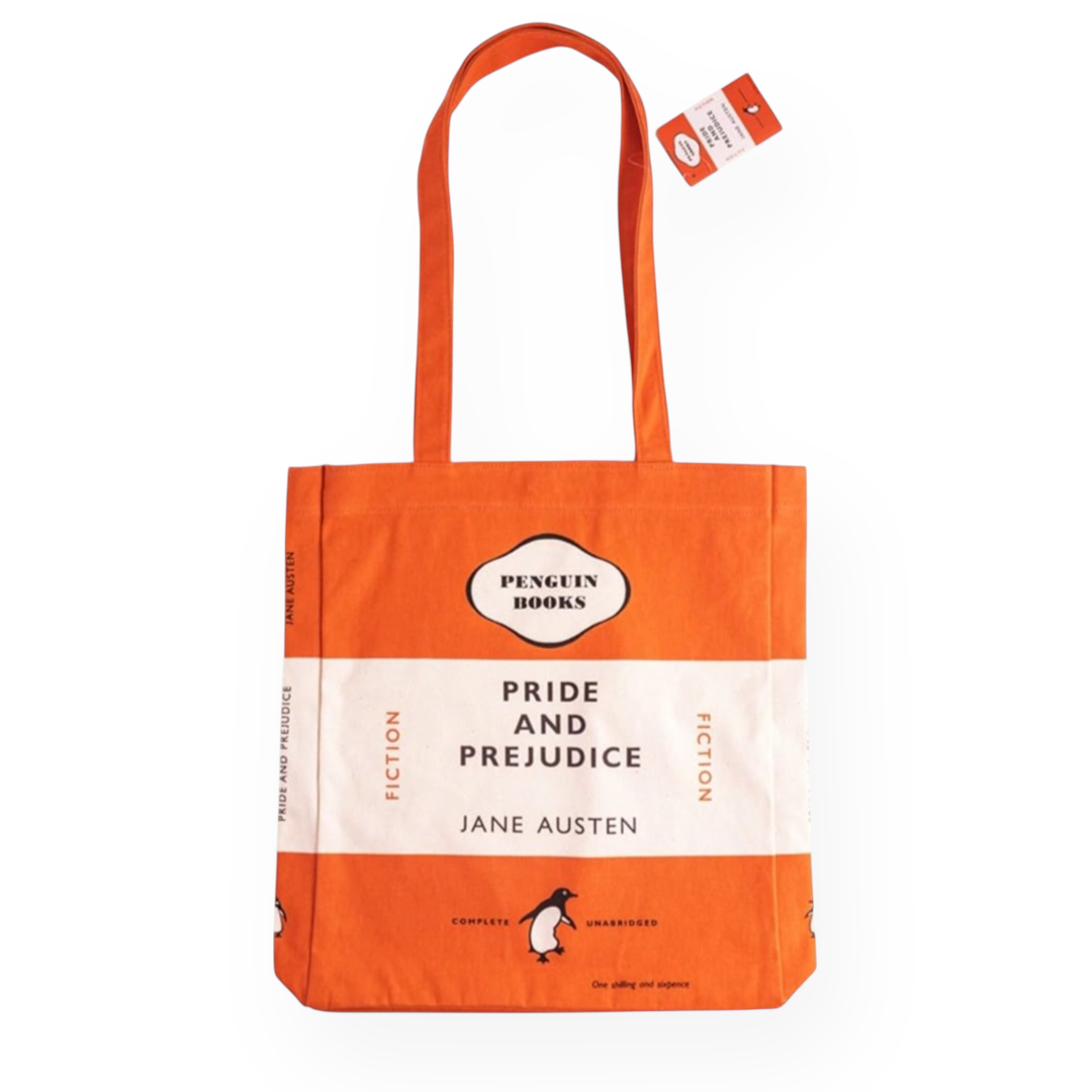 Bolsa de tela naranja y blanca inspirada en la clásica portada de la editorial Penguin de la obra Pride and Prejudice de Jane Austen con los títulos y textos en negro. Lleva una etiqueta en el asa.