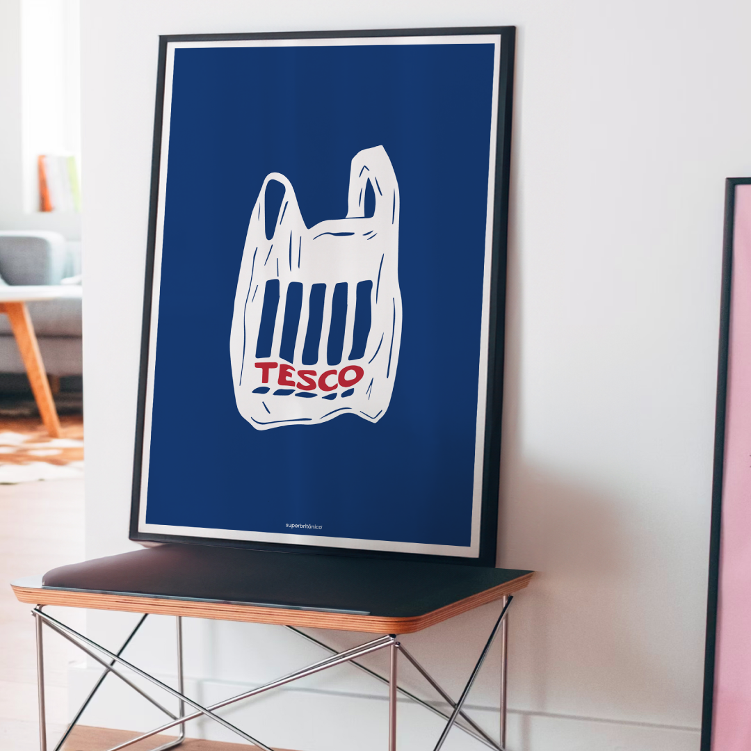 Póster ilustrado de Superbritánico con una bolsa de Tesco en blanco y rojo sobre fondo azul oscuro, apoyado sobre un mueble en un interior luminoso y moderno.