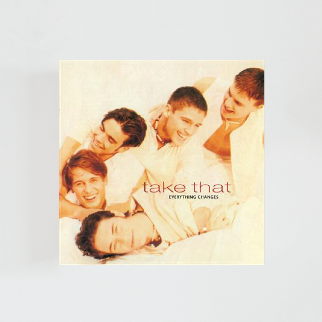 Portada del álbum Everything Changes de Take That con los cinco integrantes del grupo tumbados y sonriendo sobre un fondo en tonos cálidos, junto al nombre de la banda y el título del álbum en el centro de la imagen.