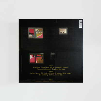 Contraportada del vinilo Favourite Worst Nightmare de Arctic Monkeys, con una ilustración de una casa oscura iluminada desde las ventanas con colores neón, álbum de rock británico de 2007.