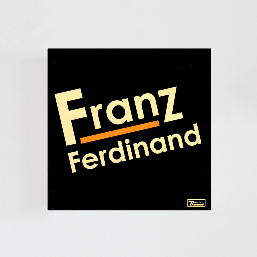 Portada del álbum homónimo “Franz Ferdinand” de Franz Ferdinand, con fondo negro y el nombre de la banda escrito en letras beige y una línea naranja bajo “Franz”.