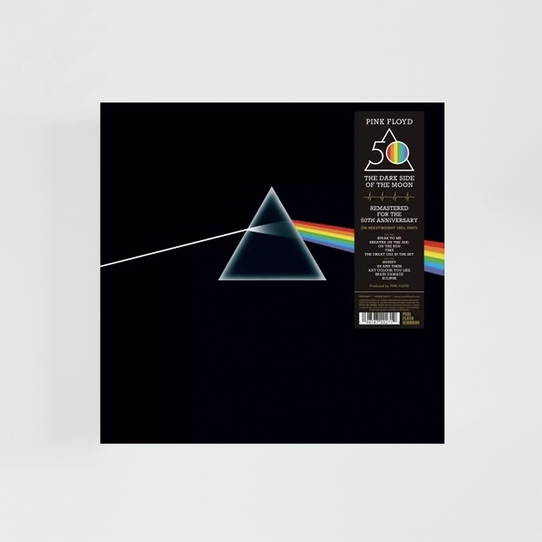 Portada del álbum The Dark Side of the Moon de Pink Floyd con un prisma sobre fondo negro que descompone un haz de luz blanca en un arcoíris. Esta edición incluye una banda vertical conmemorativa del 50.º aniversario.