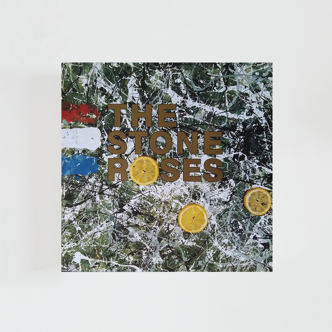 Portada del álbum The Stone Roses con una pintura abstracta de fondo en tonos verdes, amarillos y azules, salpicada de manchas y pinceladas de estilo expresionista. Sobre la composición aparecen varias rodajas de limón distribuidas por la imagen, junto a pequeñas franjas con los colores de la bandera francesa. El diseño tiene una estética artística y psicodélica, sin fotografías de la banda.