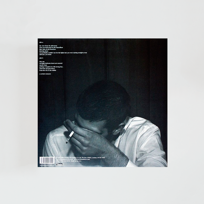 Contraportada del vinilo Whatever People Say I Am, That’s What I’m Not de Arctic Monkeys, con la icónica imagen de un hombre exhalando humo de un cigarrillo, álbum debut de rock británico de 2006.