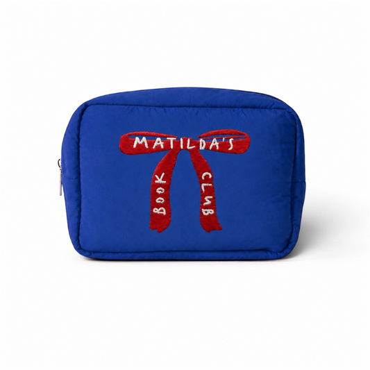 Estuche acolchado azul de Matilda’s Book Club sobre fondo blanco, con un gran lazo rojo bordado y el nombre de la colección en hilo blanco.