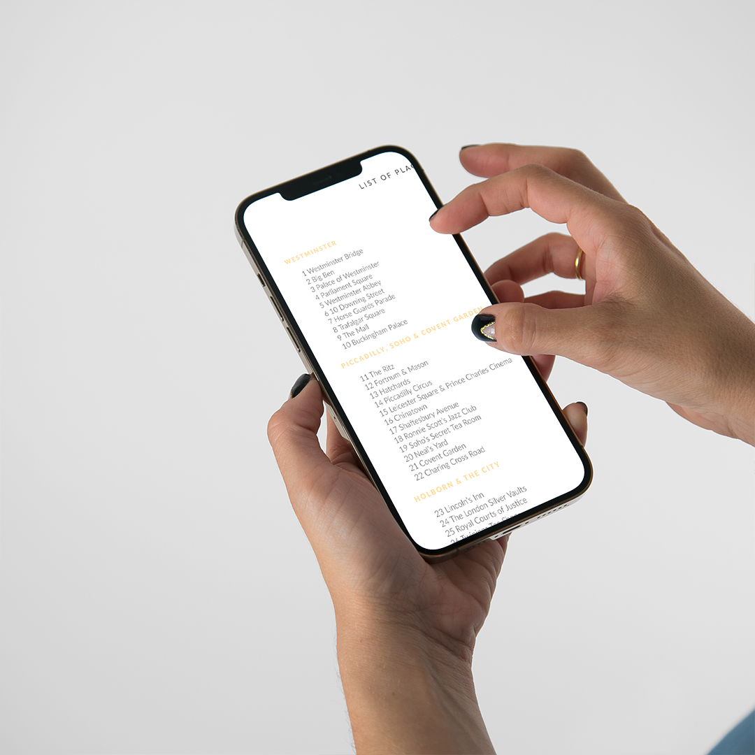 Chica señalando en el móvil el índice de monumentos de la guía digital de Londres Passport to London de Superbritánico.