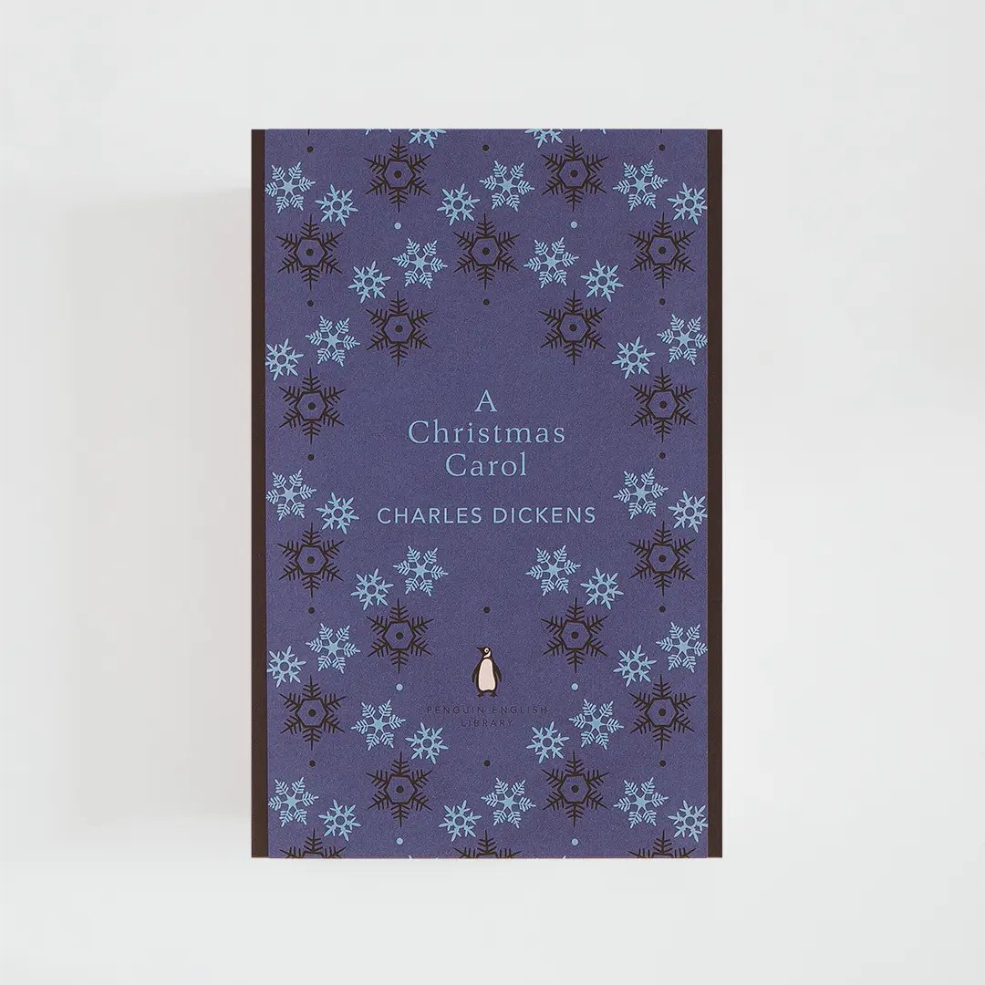 Portada azul oscuro del libro en inglés A Christmas Carol de Charles Dickens de la colección Penguin English Library sobre fondo blanco.
