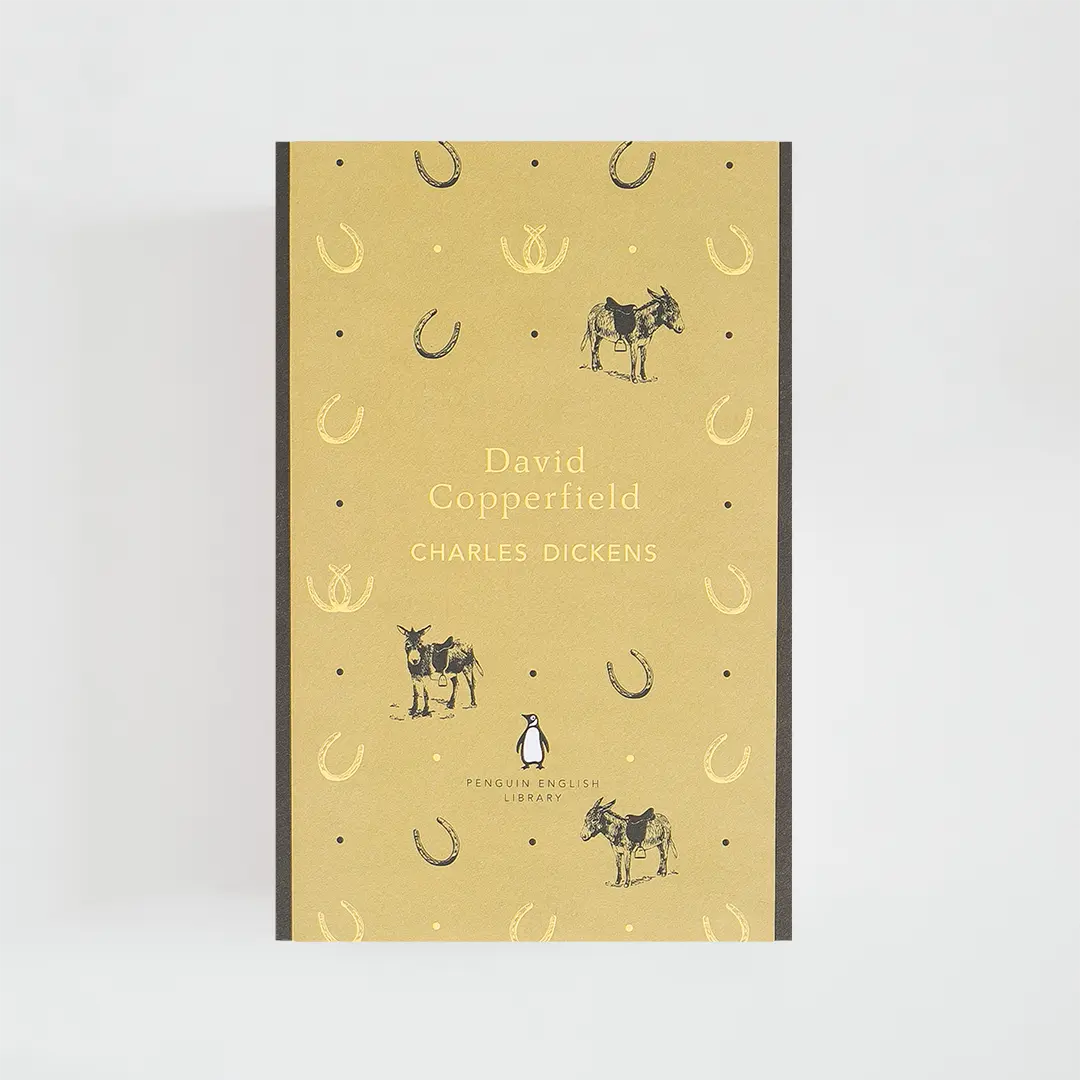 Portada amarilla y gris del libro en inglés David Copperfield de Charles Dickens de la colección Penguin English Library sobre fondo blanco.
