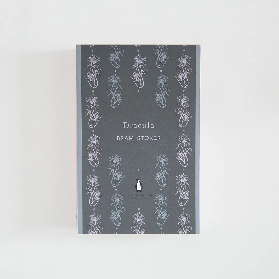 Portada en tonos grises del libro en inglés Dracula de Bram Stoker de la colección Penguin English Library sobre fondo blanco.
