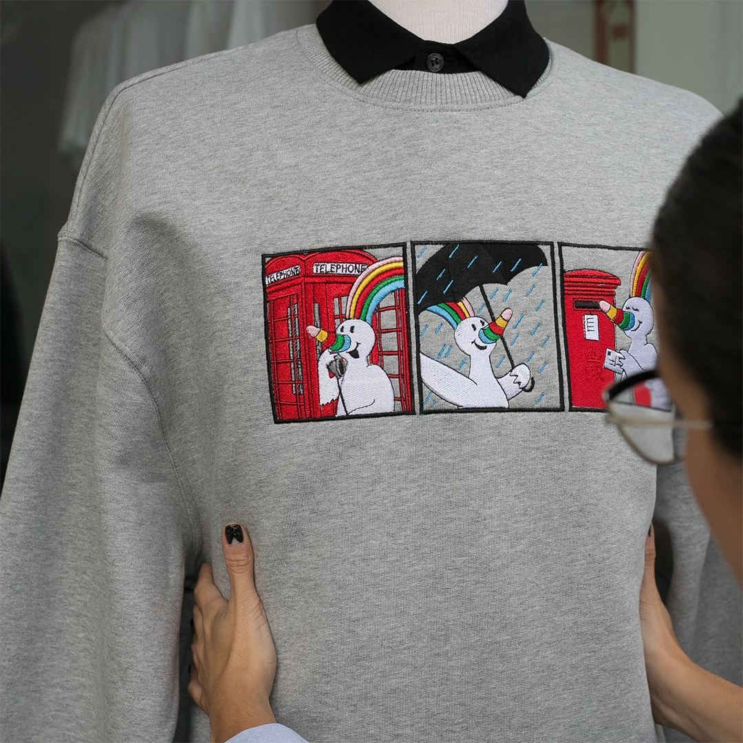 Sudadera gris con bordado de Curro in London expuesto en maniquí.