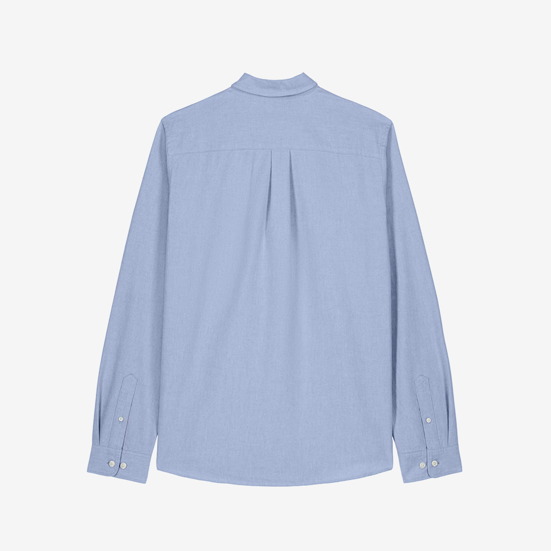 Parte trasera de camisa clásica de color celeste y corte de hombre sobre fondo blanco.