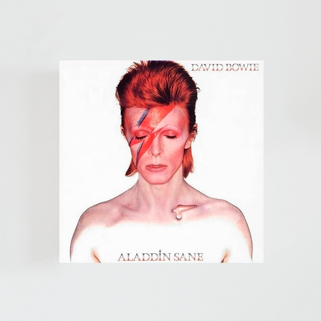 Portada del álbum “Aladdin Sane” de David Bowie, con el icónico retrato del artista sobre fondo blanco, el rostro maquillado con el rayo rojo y azul y expresión seria.
