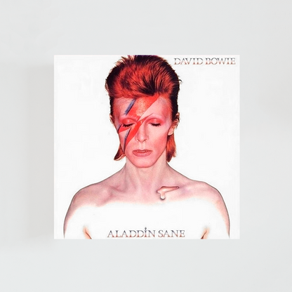 Portada del álbum “Aladdin Sane” de David Bowie, con el icónico retrato del artista sobre fondo blanco, el rostro maquillado con el rayo rojo y azul y expresión seria.