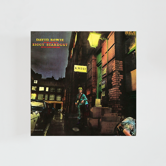 Portada del vinilo The Rise and Fall of Ziggy Stardust and the Spiders from Mars de David Bowie, con el cantante vestido como Ziggy Stardust en un callejón iluminado, álbum icónico de glam rock británico de 1972.