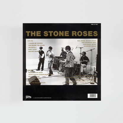 Portada del álbum The Stone Roses con fondo negro y fotografía de los integrantes del grupo tocando en un escenario blanco. Título del disco en mayúsculas y en color dorado.